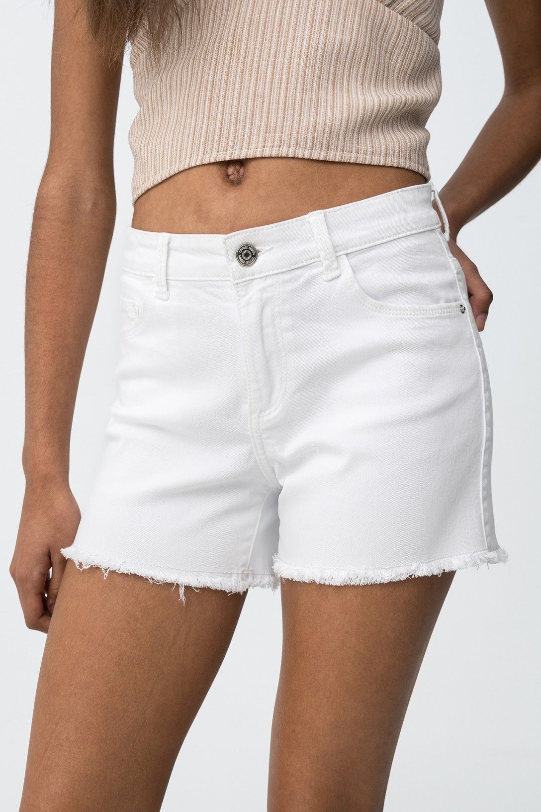 Short denim blanco con bajo deshilachado.
