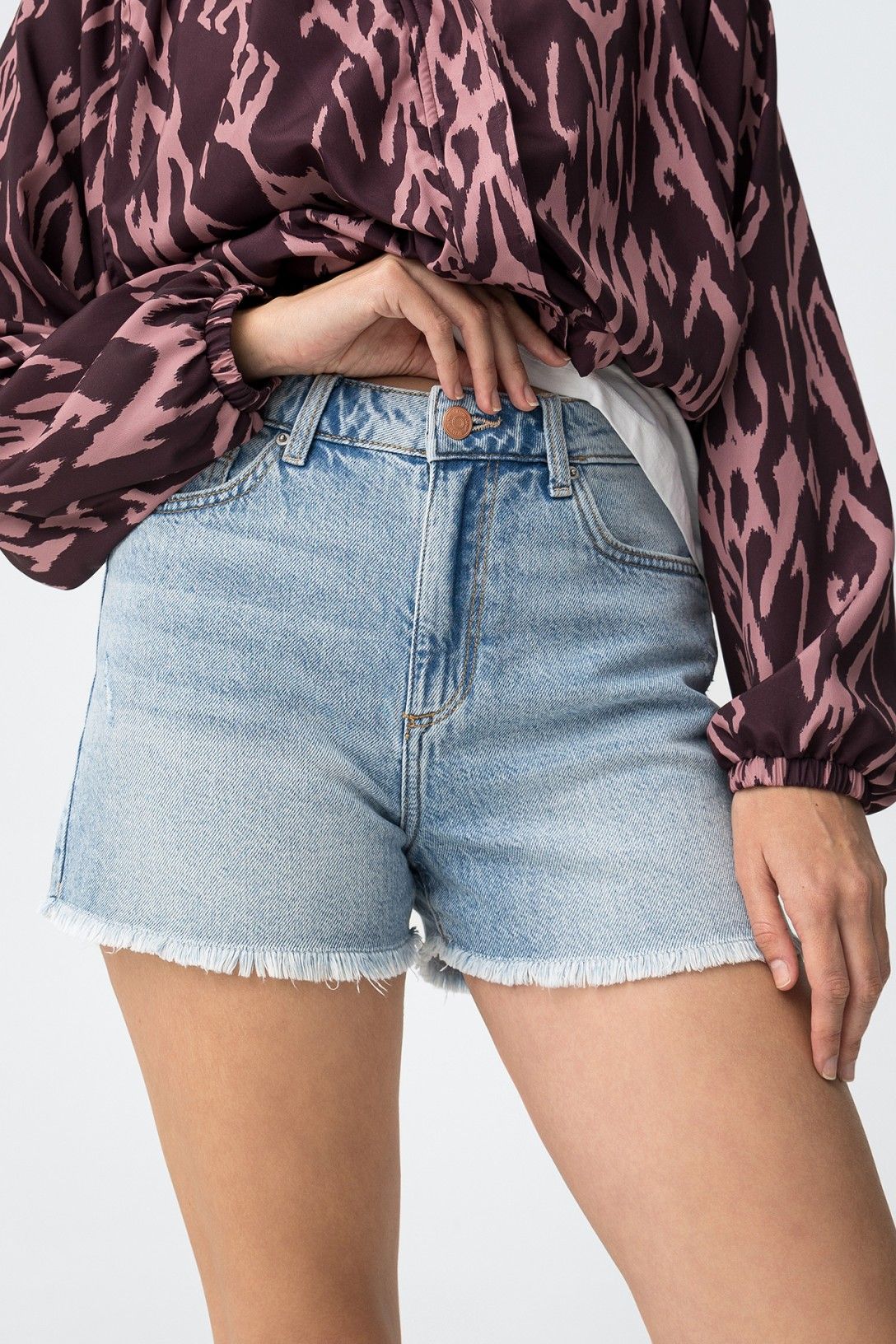 Short denim de tiro medio con acabado desflecado.