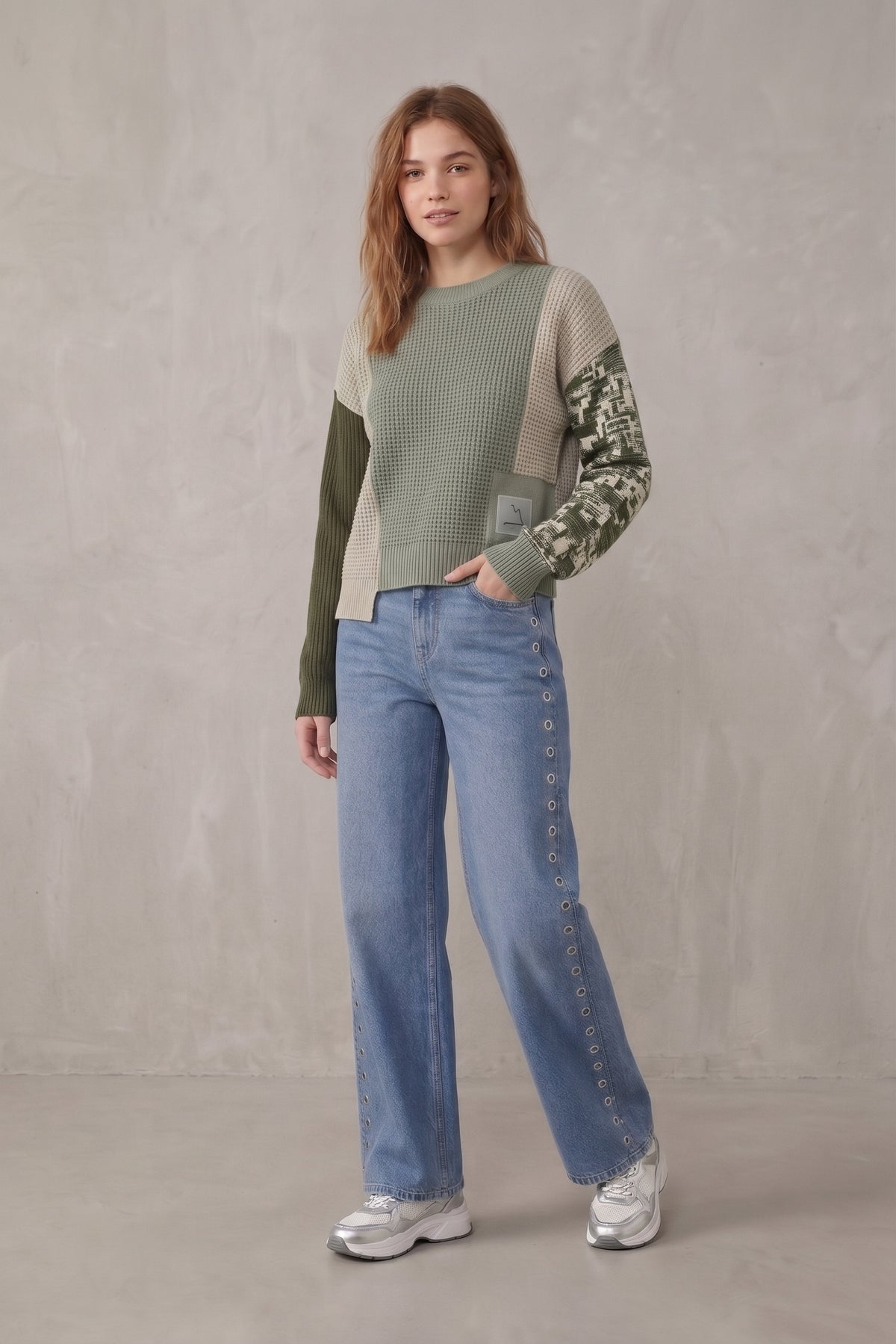 Pantalón vaquero pierna ancha con ojales metálicos.