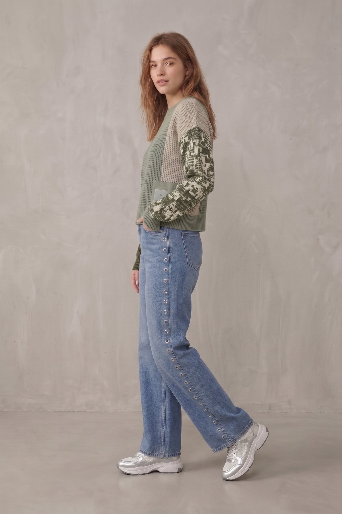 Pantalón vaquero pierna ancha con ojales metálicos.