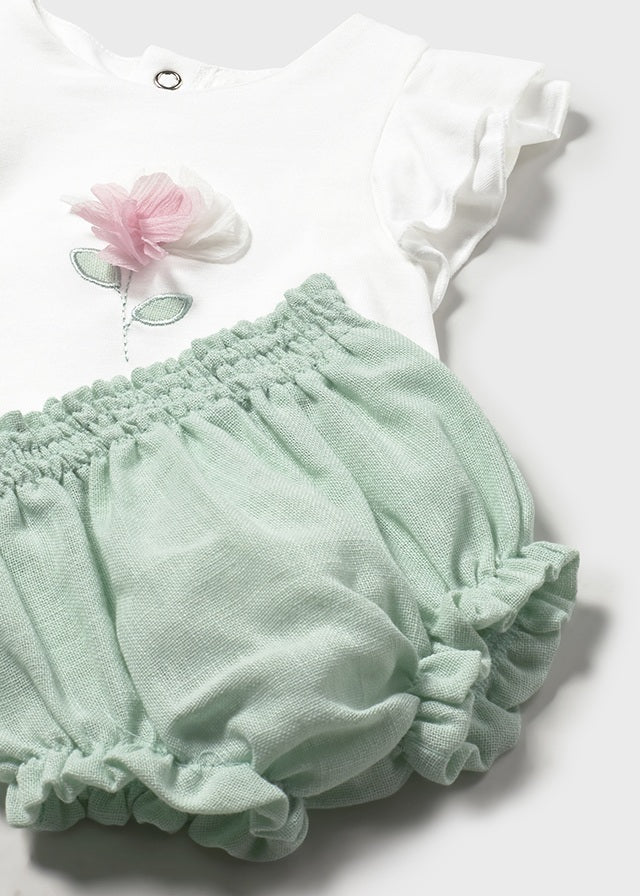 Conjunto bebé camiseta con flor y cubrepañal.