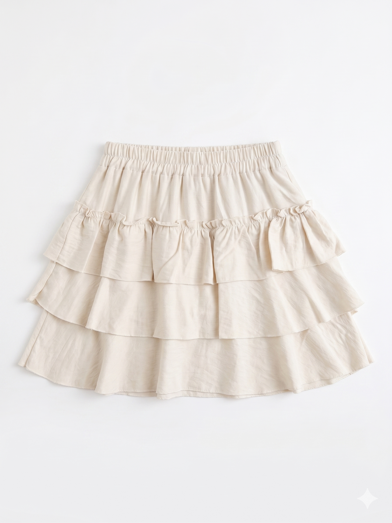 Falda corta beige con volantes y cintura elástica chica.