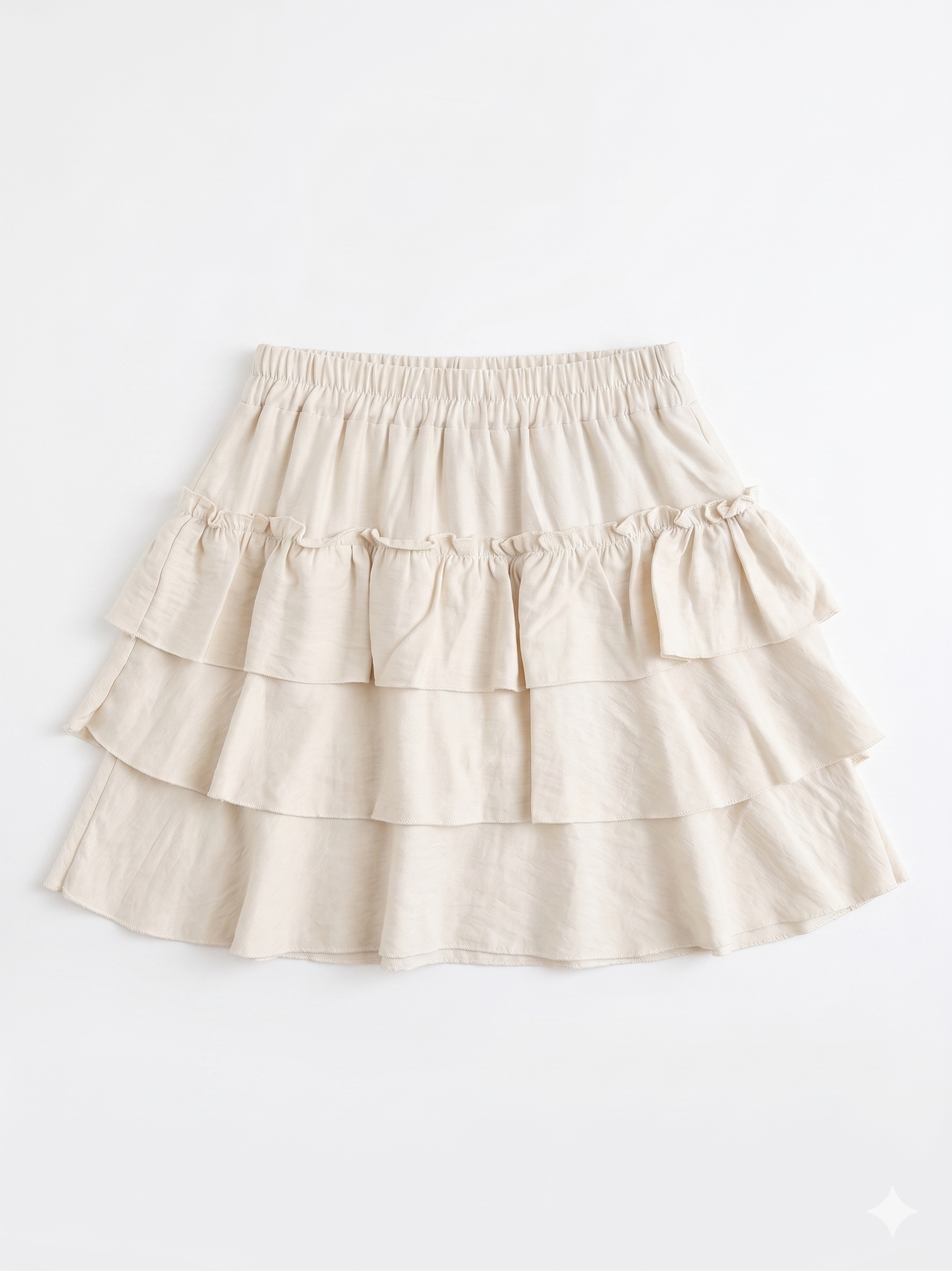 Falda corta beige con volantes y cintura elástica chica.