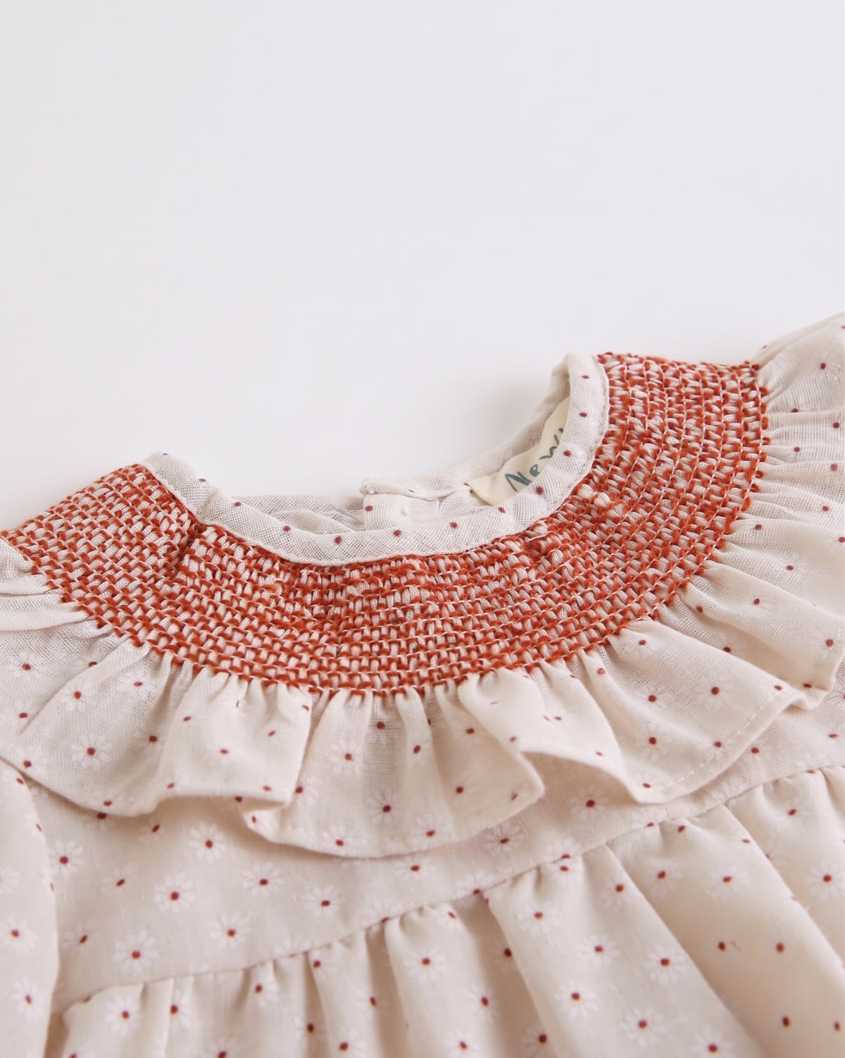 Blusa estampada manga larga cuello nido de abeja y volante bebé y niña.