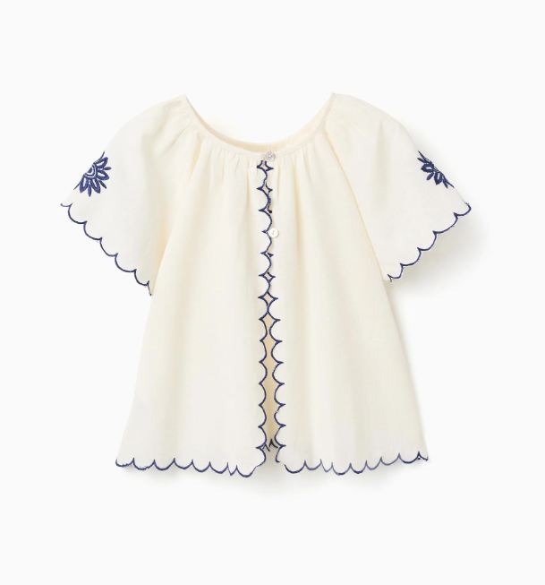 Blusa infantil con bordado y mangas onduladas.